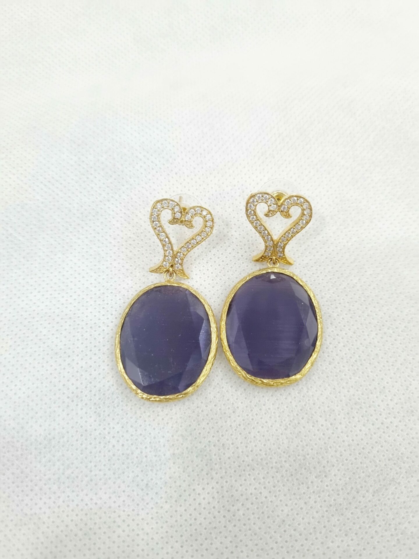 Orecchinirealizzati con occhio di gatto viola e perno in ottone con zirconi. 
Lunghezza 5cm Spedizione Gratuita