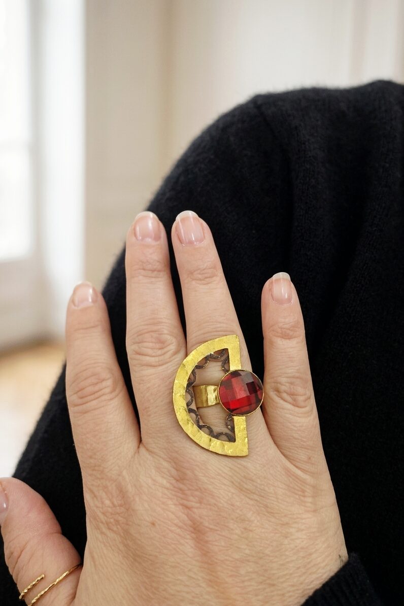 Anello geometrico regolabile realizzato in ottone battuto dorato con dettagli neri e cristalloide rosso incastonato Spedizione Gratuita