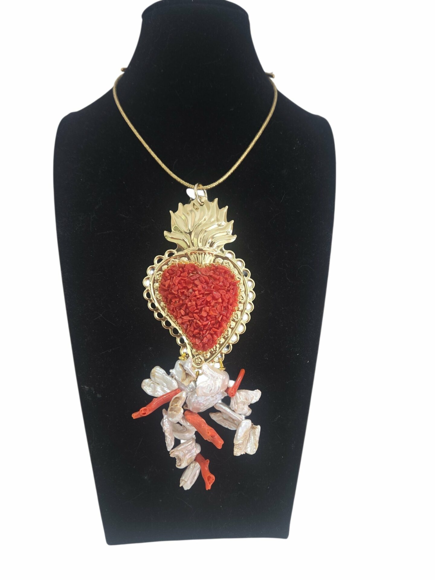 Collana con ciondolo sacro cuore rivestito di corallo e grappolo di perle barocche con corallo. Laccetto in tessuto dorato con calamita.
lunghezza ciondolo 18cm Spedizione Gratuita