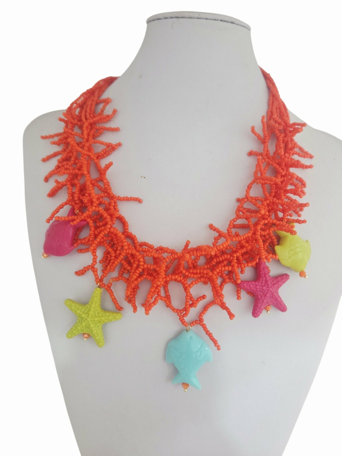 Collana girocollo  realizzata con microperline arancio, stelle e pesci multicolore in resina.
Lunghezza girocollo 58cm Spedizione Gratuita