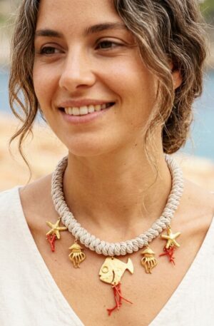 Collana girocollo regolabile realizzata artigianalmente  om cordone lavorato a mano,pesci stelle e meduse in ottone e rametti di corallo.
lunghezza 50cm Spedizione Gratuita